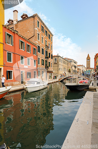 Image of Venice, Italy. Tourists walking at sidewalks aside to canals in historic part of the city