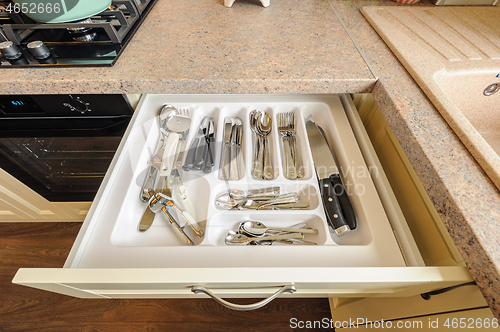 Image of open kitchen drawer with silverware inside