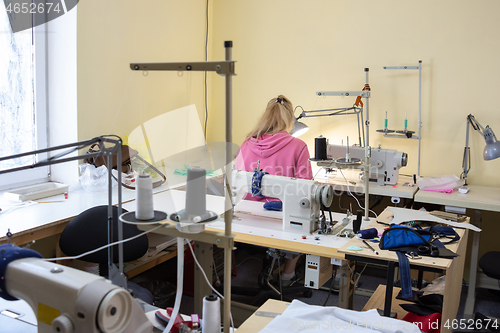 Image of a room with sewing equipment and one female employee