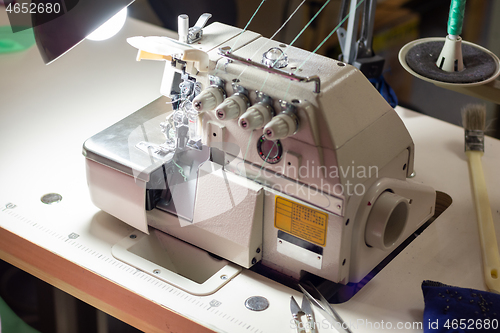 Image of a industrial sewing equipment with many threads