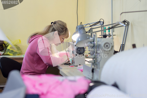 Image of Worker in sewing workshop sews on a professional sewing machine