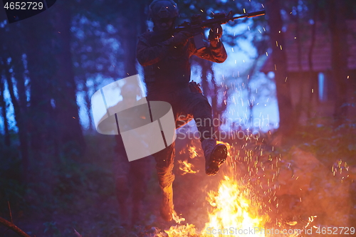 Image of Soldier in Action at Night jumping over fire