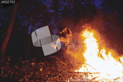 Image of Soldier in Action at Night jumping over fire