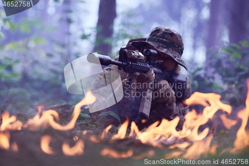 Image of soldier in action aiming  on weapon  laser sight optics