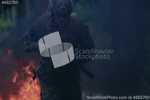 Image of Soldier in Action at Night jumping over fire