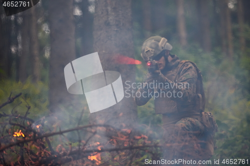 Image of soldier in action aiming  on weapon  laser sight optics