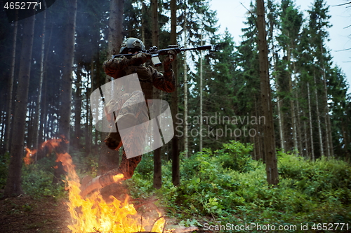 Image of Soldier in Action at Night jumping over fire