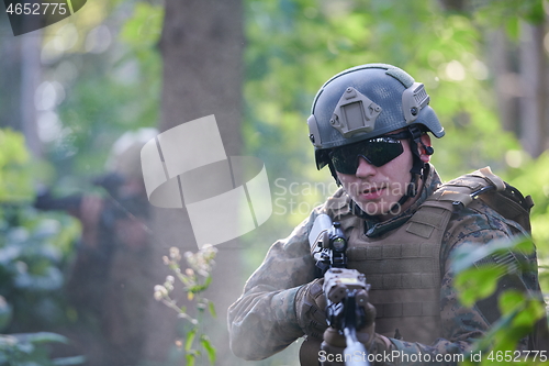 Image of soldier in action aiming  on weapon  laser sight optics