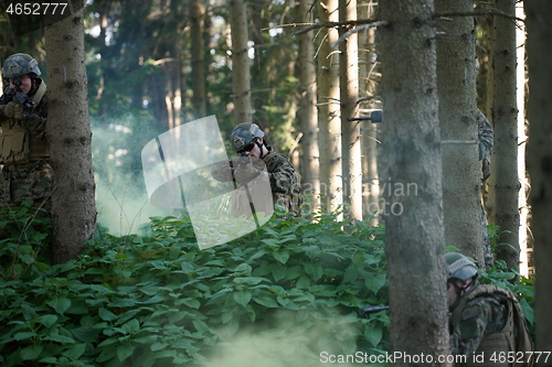 Image of soldier in action aiming  on laser sight optics