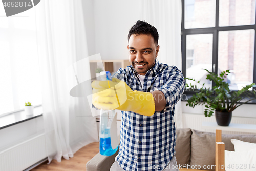 Image of smiling indian man with detergent cleaning at home