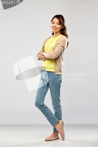 Image of happy asian woman over grey background