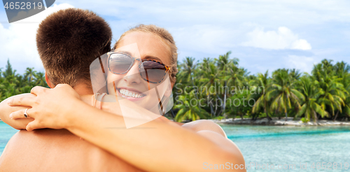 Image of happy couple hugging on summer beach