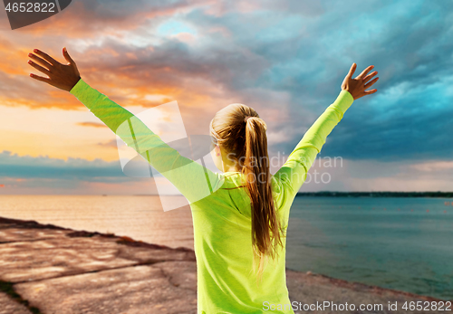 Image of happy woman in sports clothes at seaside