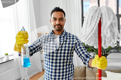 Image of indian man with mop and detergent cleaning at home