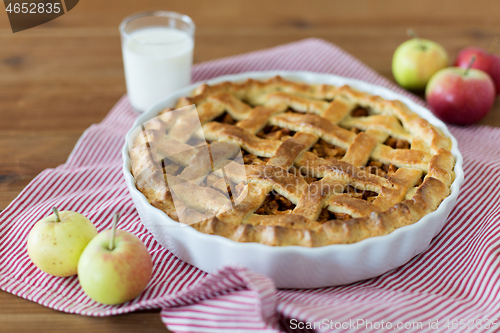 Image of apple pie in baking mold on wooden table