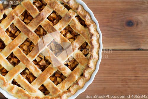 Image of close up of apple pie in mold on wooden table