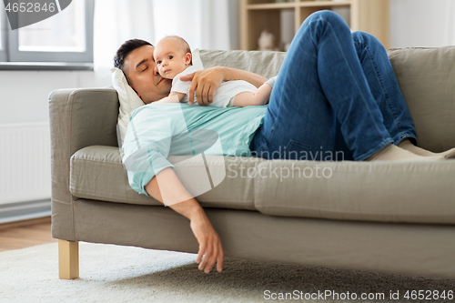 Image of father with baby sleeping on sofa at home