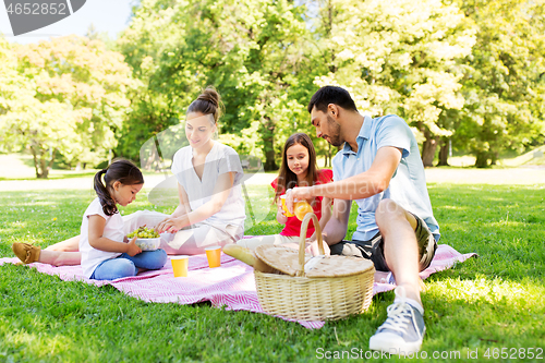 Image of happy family having picnic at summer park