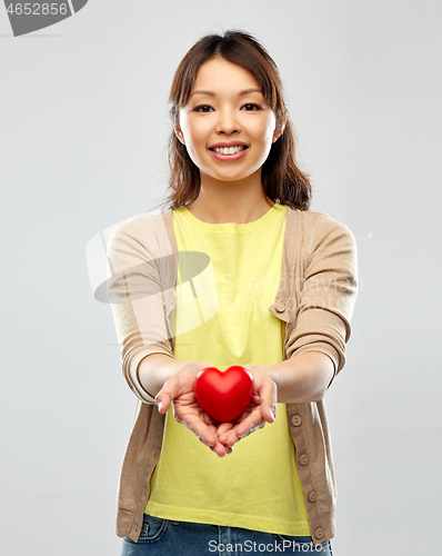 Image of happy asian woman holding red heart