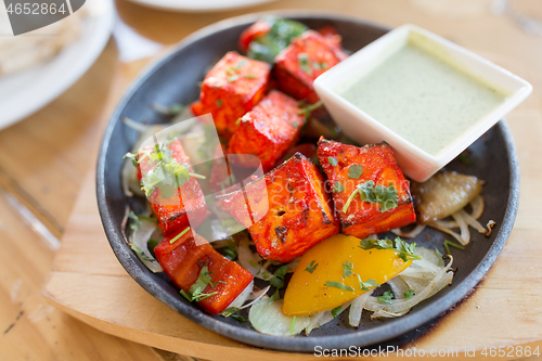 Image of close up of paneer tikka dish with sauce on table