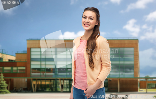 Image of smiling young student woman over school background