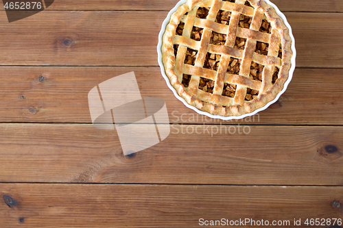 Image of close up of apple pie in mold on wooden table