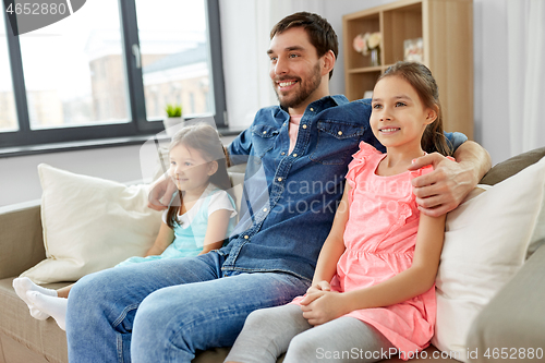 Image of happy father with daughters on sofa at home