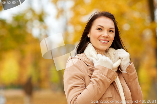 Image of beautiful happy young woman smiling in autumn park