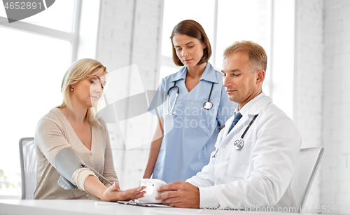 Image of doctor measuring patient woman\'s blood pressure