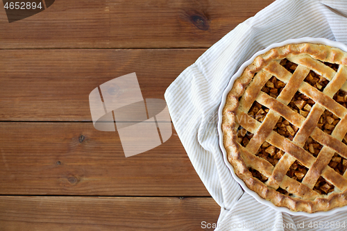 Image of close up of apple pie in mold on wooden table