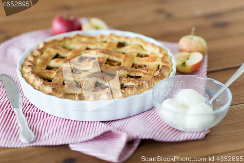 Image of apple pie with ice cream on wooden table