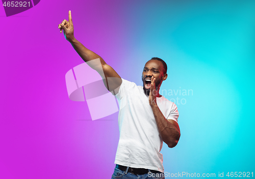 Image of African-american young man\'s portrait on gradient studio background in neon