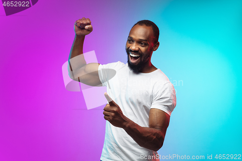 Image of African-american young man\'s portrait on gradient studio background in neon