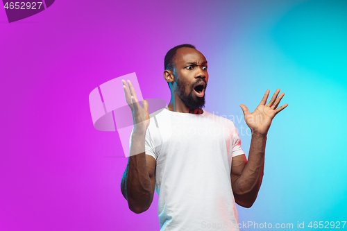 Image of African-american young man\'s portrait on gradient studio background in neon