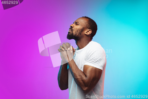 Image of African-american young man\'s portrait on gradient studio background in neon