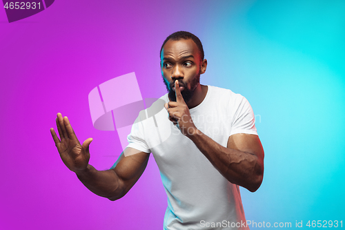 Image of African-american young man\'s portrait on gradient studio background in neon