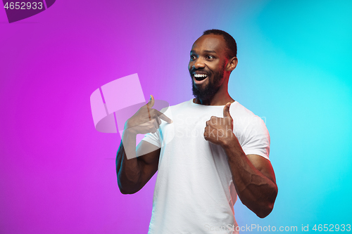 Image of African-american young man\'s portrait on gradient studio background in neon