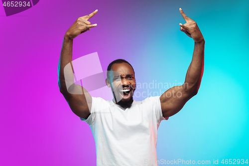 Image of African-american young man\'s portrait on gradient studio background in neon