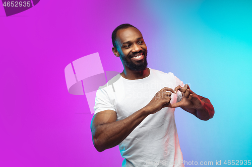 Image of African-american young man\'s portrait on gradient studio background in neon