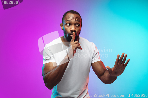 Image of African-american young man\'s portrait on gradient studio background in neon