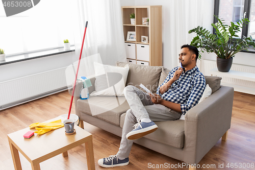 Image of indian man with to do list after home cleaning