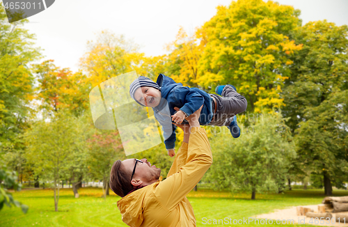 Image of father with son playing and having fun in autumn