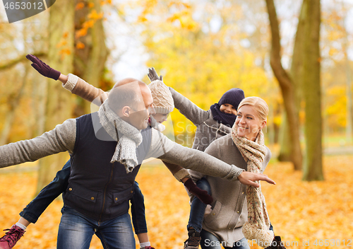 Image of happy family having fun in autumn park