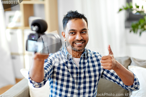 Image of male video blogger with camera blogging at home