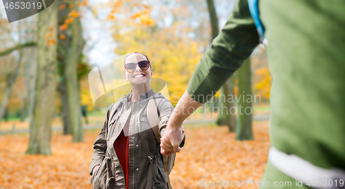 Image of happy couple with backpacks hiking outdoors