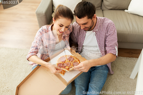 Image of couple eating takeaway pizza at home