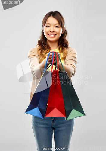 Image of happy asian woman with shopping bags