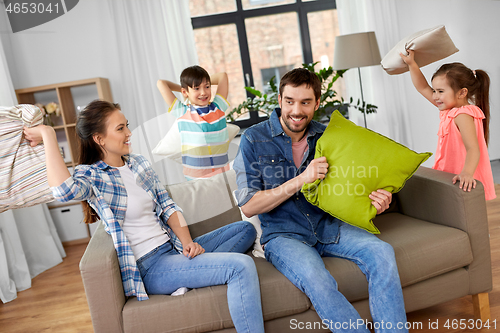 Image of happy family having pillow fight at home