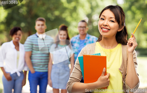 Image of asian student woman with books and pencil