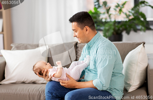 Image of middle aged father with baby daughter at home